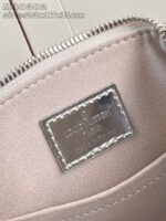 Interno di borsa Louis Vuitton con tag in ottone e fodera satinata elegante.