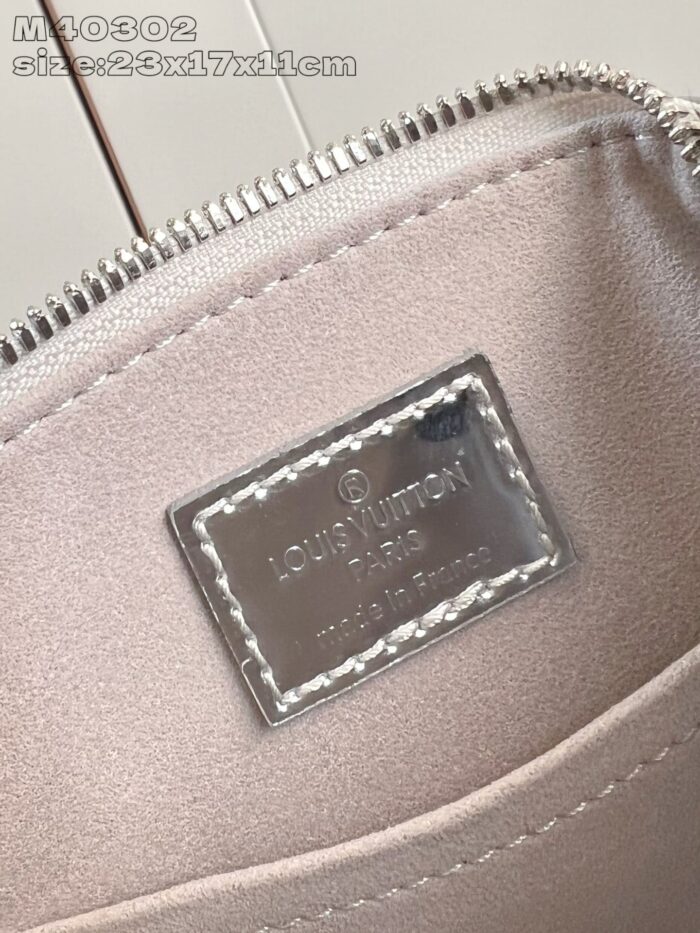 Interno di borsa Louis Vuitton con tag in ottone e fodera satinata elegante.