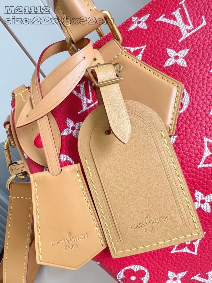 Etichette da bagaglio Louis Vuitton in pelle tan su borsa monogramma rosa vibrante.