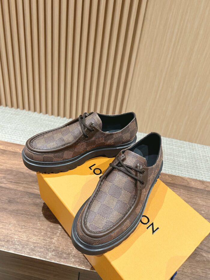 Scarpe Louis Vuitton slip-on in cuoio con logo iconico su scatola arancione, stile elegante e casual.