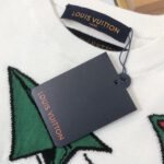 Maglione Louis Vuitton bianco con ricamo a foglia verde e etichetta elegante.