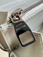 Dettaglio zip Louis Vuitton in pelle di lusso, logo inciso, eleganza e qualità italiana.