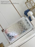 Scatola di lusso in metallo riflettente con monogramma Louis Vuitton e dettagli eleganti.