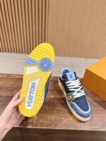 Sneaker di lusso navy con suola gialla vibrante, design elegante e stile innovativo.