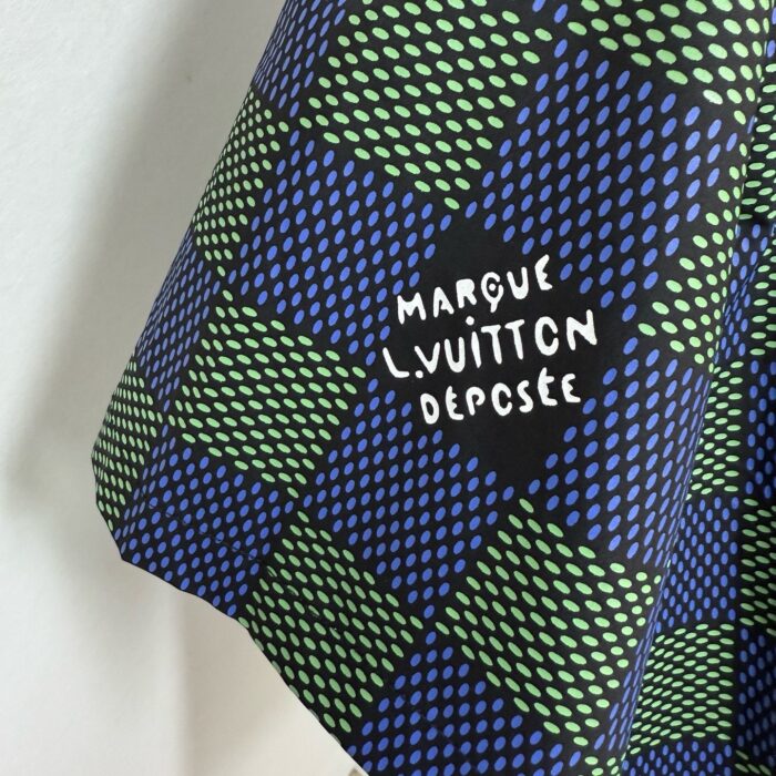 Tessuto di lusso blu e verde con logo Louis Vuitton, pattern geometrico e dettagli eleganti.