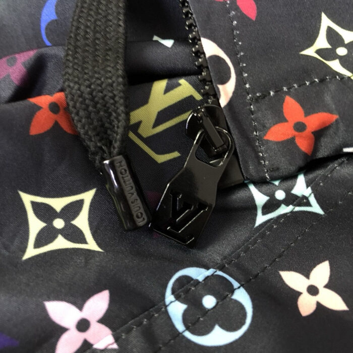 Dettaglio di zip su borsa di lusso con motivi floreali e design elegante.