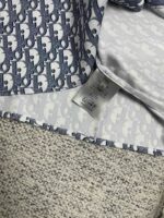 Dettaglio di abbigliamento di lusso con pattern blu e finiture di alta qualità.