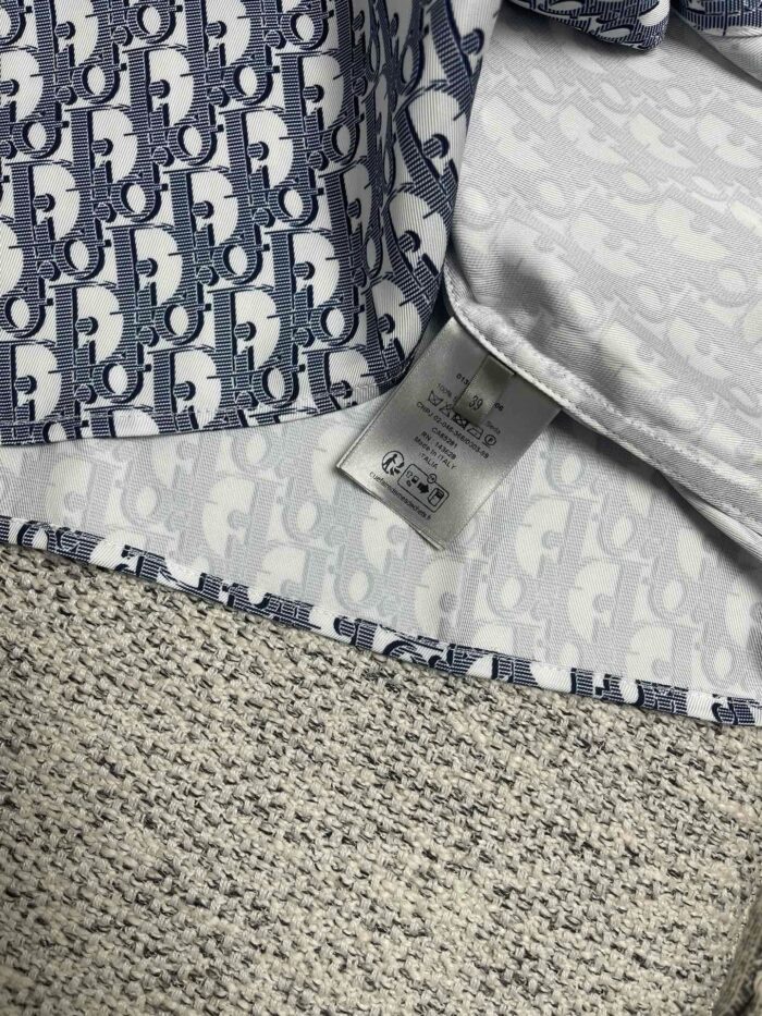 Dettaglio di abbigliamento di lusso con pattern blu e finiture di alta qualità.