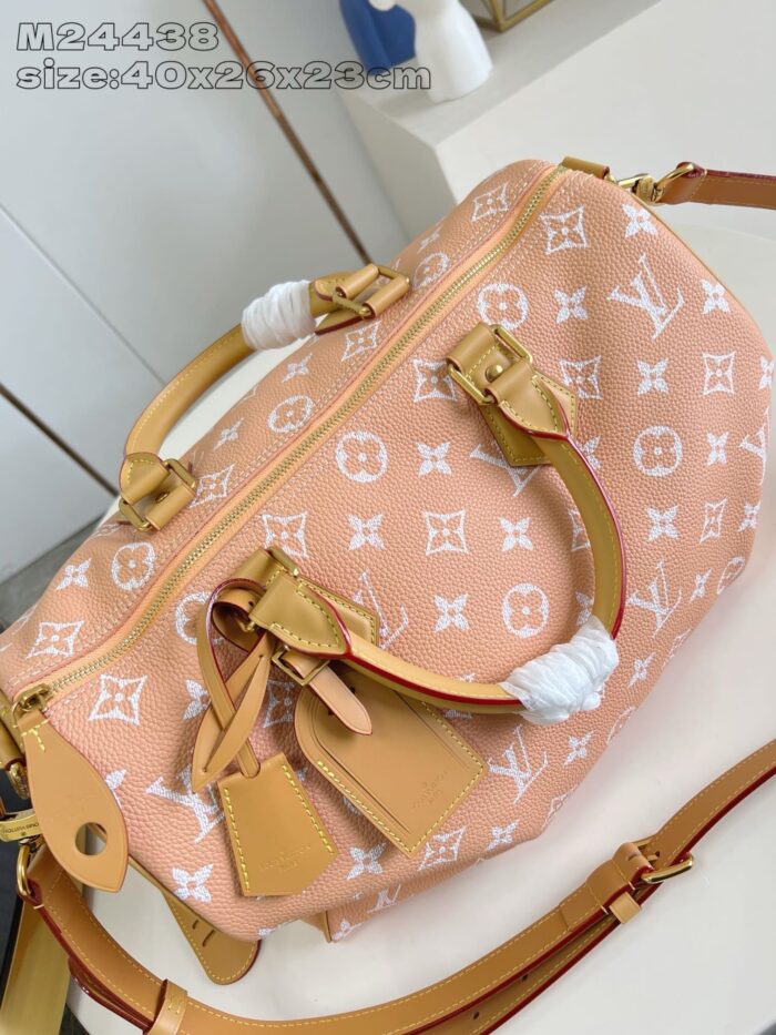 Borsa Louis Vuitton in tela pesca con manici e tracolla in pelle dorata, elegante e di lusso.