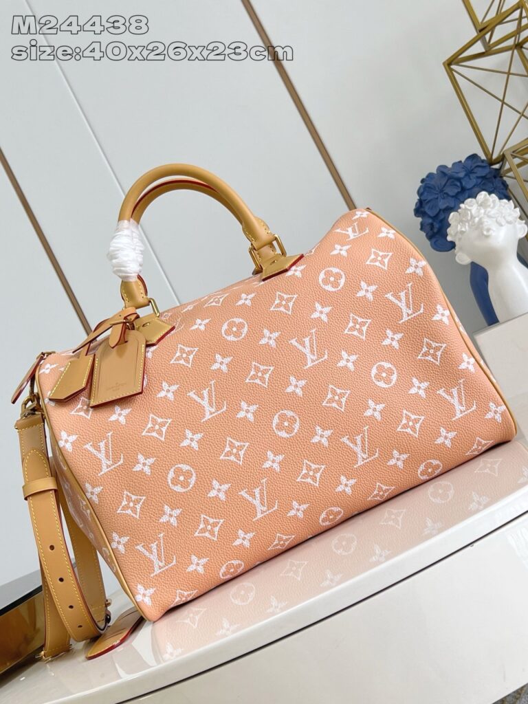 Borsa Louis Vuitton in pelle pesca con dettagli dorati e tracolla regolabile elegante.