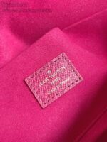 Fondo in tessuto rosa di lusso con etichetta Louis Vuitton, simbolo di eleganza e prestigio.