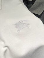 Polo di lusso con logo ricamato tono su tono di un leone in stile elegante e discreto.