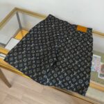Pantaloncini Louis Vuitton monogramma neri su vetrina con dettagli in pelle caramel.