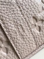Accessorio in pelle quilted di lusso con motivi floreali embossati, elegante e di alta qualità.