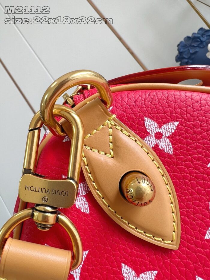 Borsa in pelle rossa con dettagli dorati, design elegante e stile sofisticato.