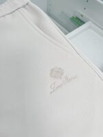 Tessuto satinato di lusso con logo elegante e raffinato, perfetto per capi di alta moda.