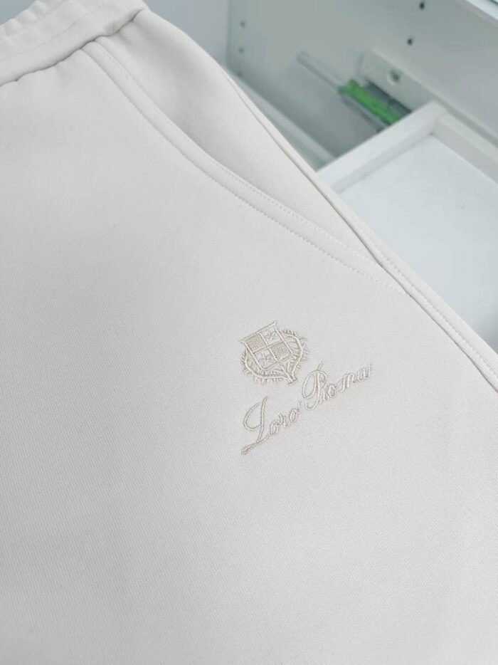 Tessuto satinato di lusso con logo elegante e raffinato, perfetto per capi di alta moda.