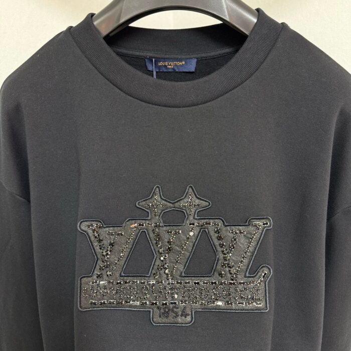 Felpa nero con logo LVY decorato con paillettes e dettagli di corona glamour.