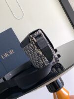 Borsa Dior elegante su tavolo raffinato con libro blu e dettagli in legno arancione.