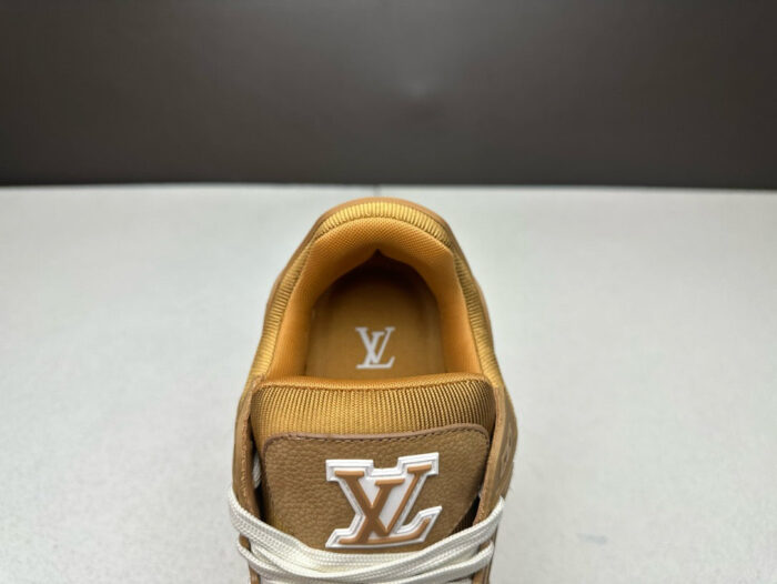 Sneaker di lusso in suede marrone con logo distintivo, dettagli eleganti e lacci bianchi.