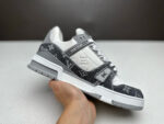 Sneaker di lusso grigia e bianca con monogramma, stile sportivo e design elegante.