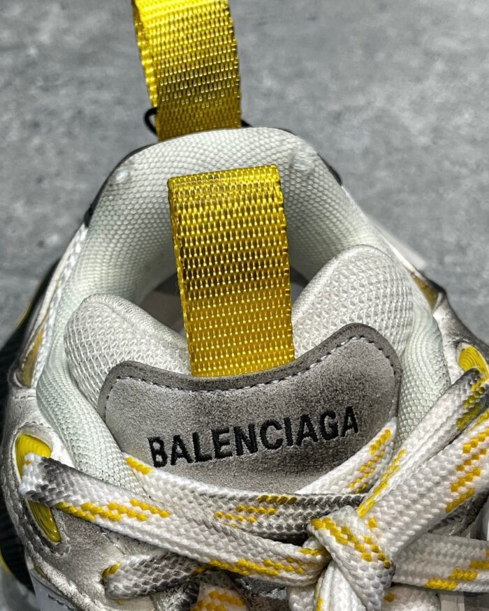 Sneaker Balenciaga bianca con dettagli gialli, stile moderno e design di lusso.
