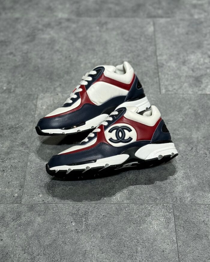 Scarpe da ginnastica di lusso in navy, bianco e rosso, stile streetwear elegante e moderno.