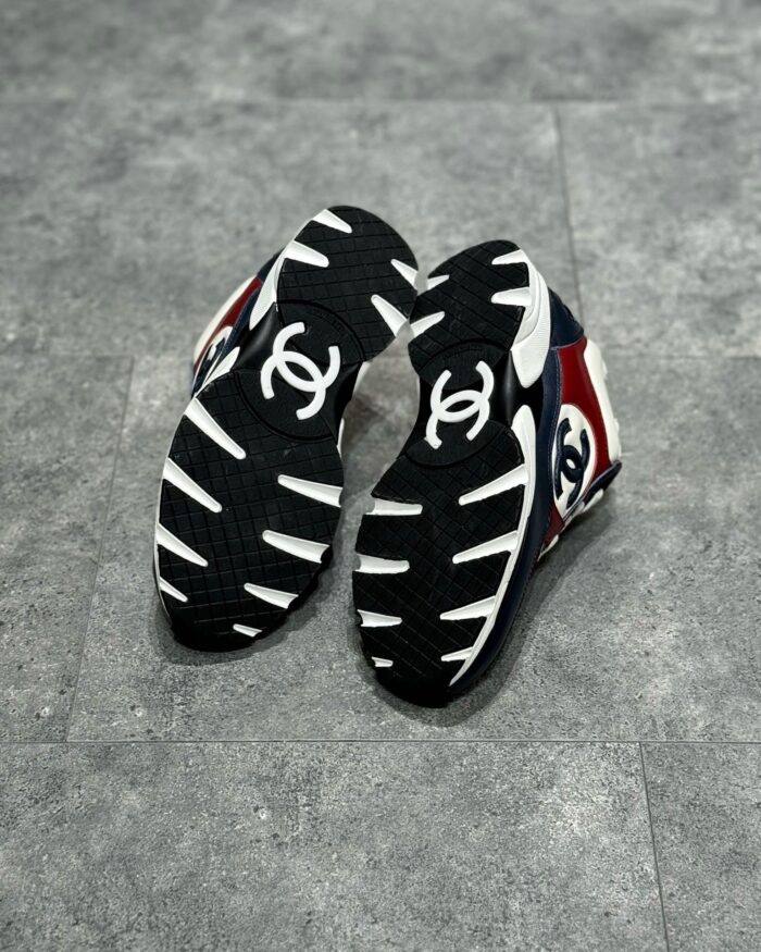 Scarpe di lusso moderne in nero, rosso e bianco con suola dinamica e logo elegante.