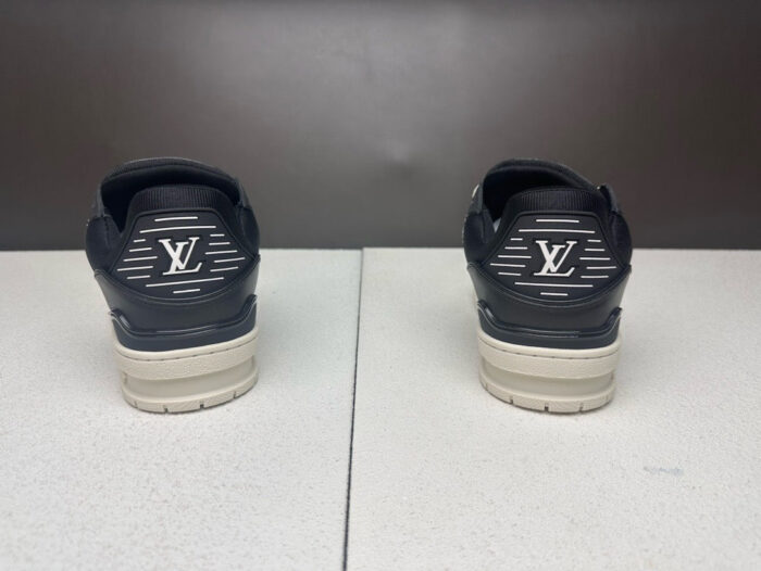Sneakers nere di lusso con dettagli beige, logo prominente e suola testurizzata per stile e comfort.