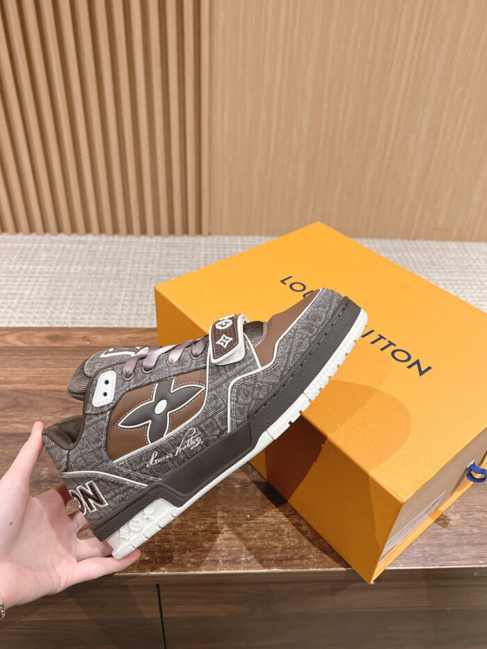 Sneaker di lusso marrone con scatola arancione, stile elegante in ambiente sofisticato.