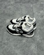 Sneakers nere e bianche con logo iconico, stile moderno e suola in gomma per look urbano elegante.