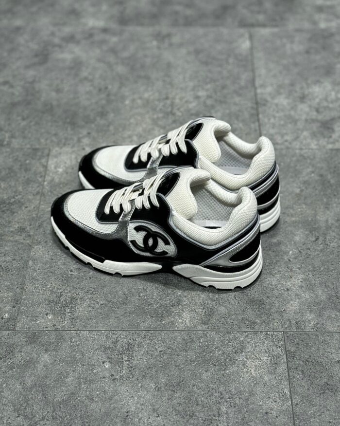 Sneakers nere e bianche con logo iconico, stile moderno e suola in gomma per look urbano elegante.