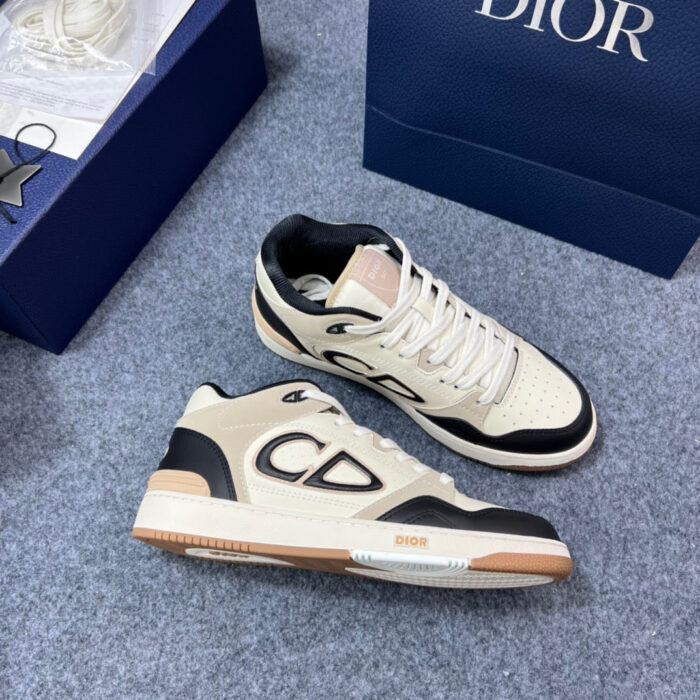 Sneakers di lusso cream e nero con logo CD, suola trasparente e scatola elegante.