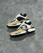 Sneaker di lusso in cream, nero e taino, design moderno, dettagli in pelle e tessuto, suola antiscivolo.