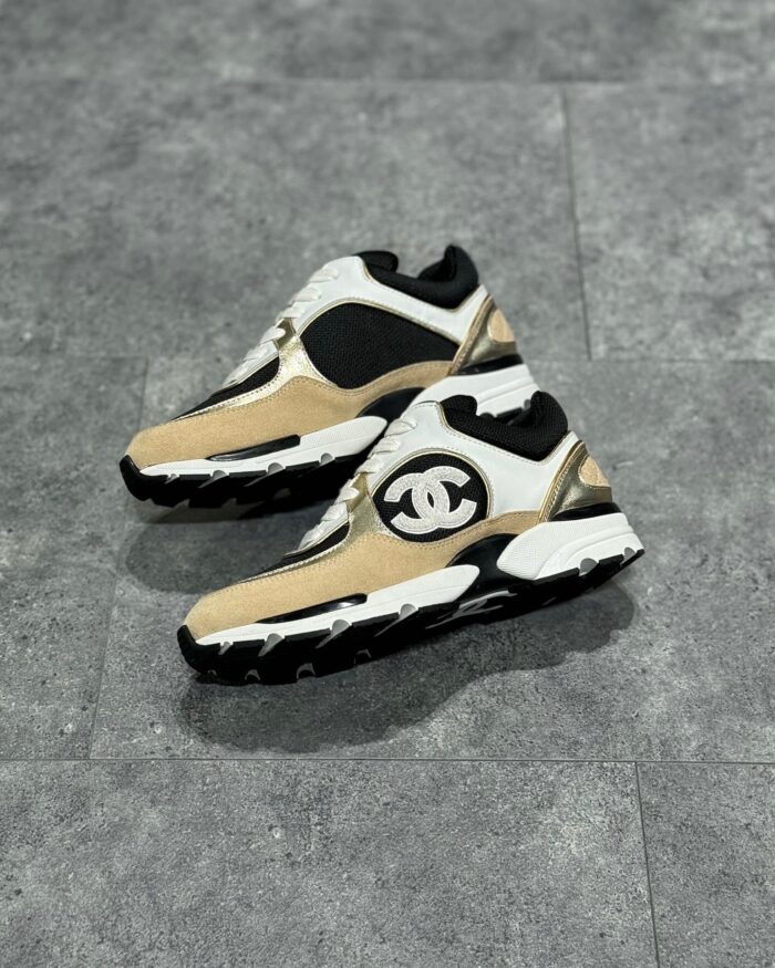 Sneaker di lusso in cream, nero e taino, design moderno, dettagli in pelle e tessuto, suola antiscivolo.