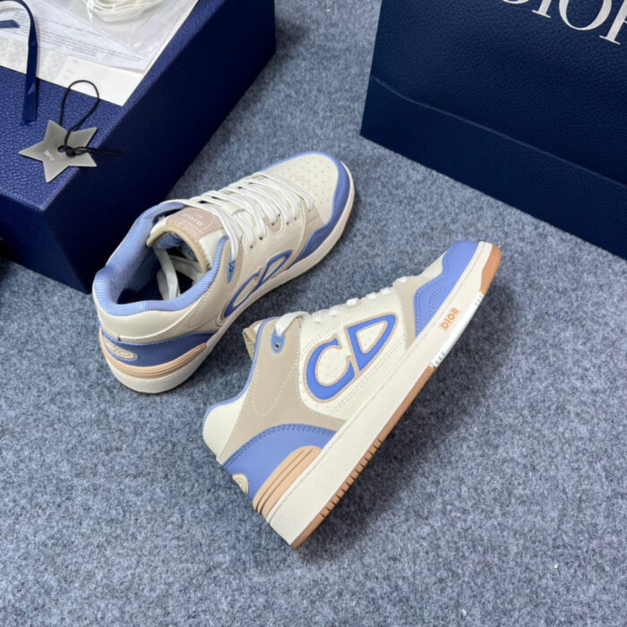 Sneaker di lusso crema e azzurro con logo CD, eleganti e moderne, su sfondo neutro.