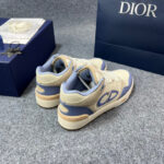 Sneakers di lusso bianche crema, blu e beige con logo CD e dettagli eleganti.