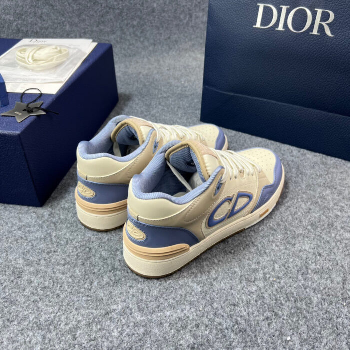 Sneakers di lusso bianche crema, blu e beige con logo CD e dettagli eleganti.