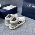 Sneaker Dior di lusso bianca e grigia con borsa navy e branding elegante, stile esclusivo.