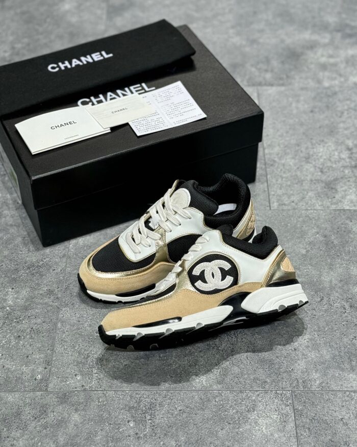 Sneakers di lusso cream e nero con packaging elegante, stile moderno e dettagli distintivi.