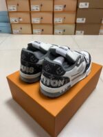 Sneaker di lusso bianco e nero su scatola arancione, stile moderno e dettagli premium.
