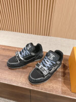 Sneakers di lusso con lacci blu, dettagli eleganti e packaging arancione su sfondo in legno.