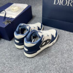 Sneakers di lusso bianche con dettagli navy, presentate con elegante scatola regalo blu raffinata.