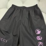 Shorts sportivi neri Gucci con logo rosa, stile moderno e comfort di alta moda.