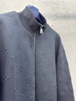 Giacca nera di lusso con monogramma, collo alto e dettagli moderni in stile esclusivo.