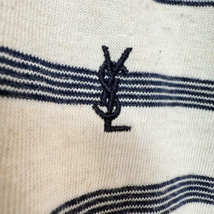 T-shirt a righe Yves Saint Laurent con logo ricamato in blu navy su tessuto neutro.