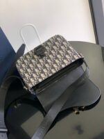 Borsa di lusso con motivo geometrico, dettagli eleganti e tracolla versatile su superficie lucida.