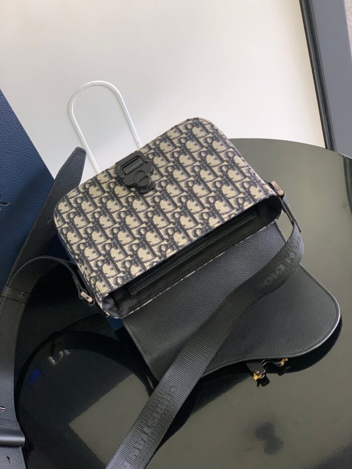 Borsa di lusso con motivo geometrico, dettagli eleganti e tracolla versatile su superficie lucida.