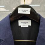Blazer navy Thom Browne, made in Japan, elegante e sartoriale, dettaglio interno con etichette di qualità.