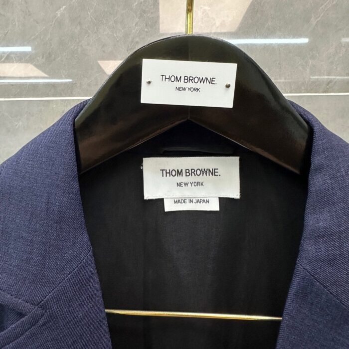 Blazer navy Thom Browne, made in Japan, elegante e sartoriale, dettaglio interno con etichette di qualità.